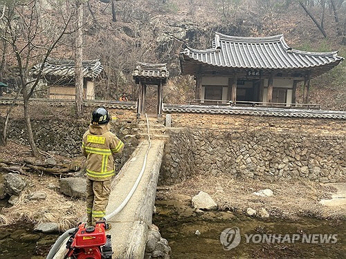 지난 22일 경북 의성에서 난 산불이 바람을 타고 동진하면서 안동까지 번진 가운데 경북도소방본부 관계자가 25일 안동 길안면 묵계리 만휴정을 둘러보고 있다. 만휴정은 조선시대인 1706년 문신인 보백당(寶白堂) 김계행이 만년을 보내기 위해 건립한 곳으로 경상북도 문화유산자료로 지정돼 있다. [경북도소방본부 제공=연합뉴스]